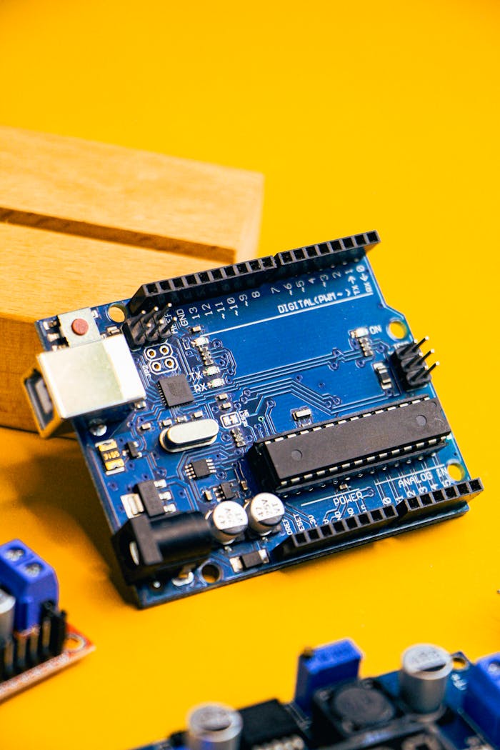 ours-journey Close-up of an Arduino microcontroller on a vibrant yellow background, showcasing electronic innovation.